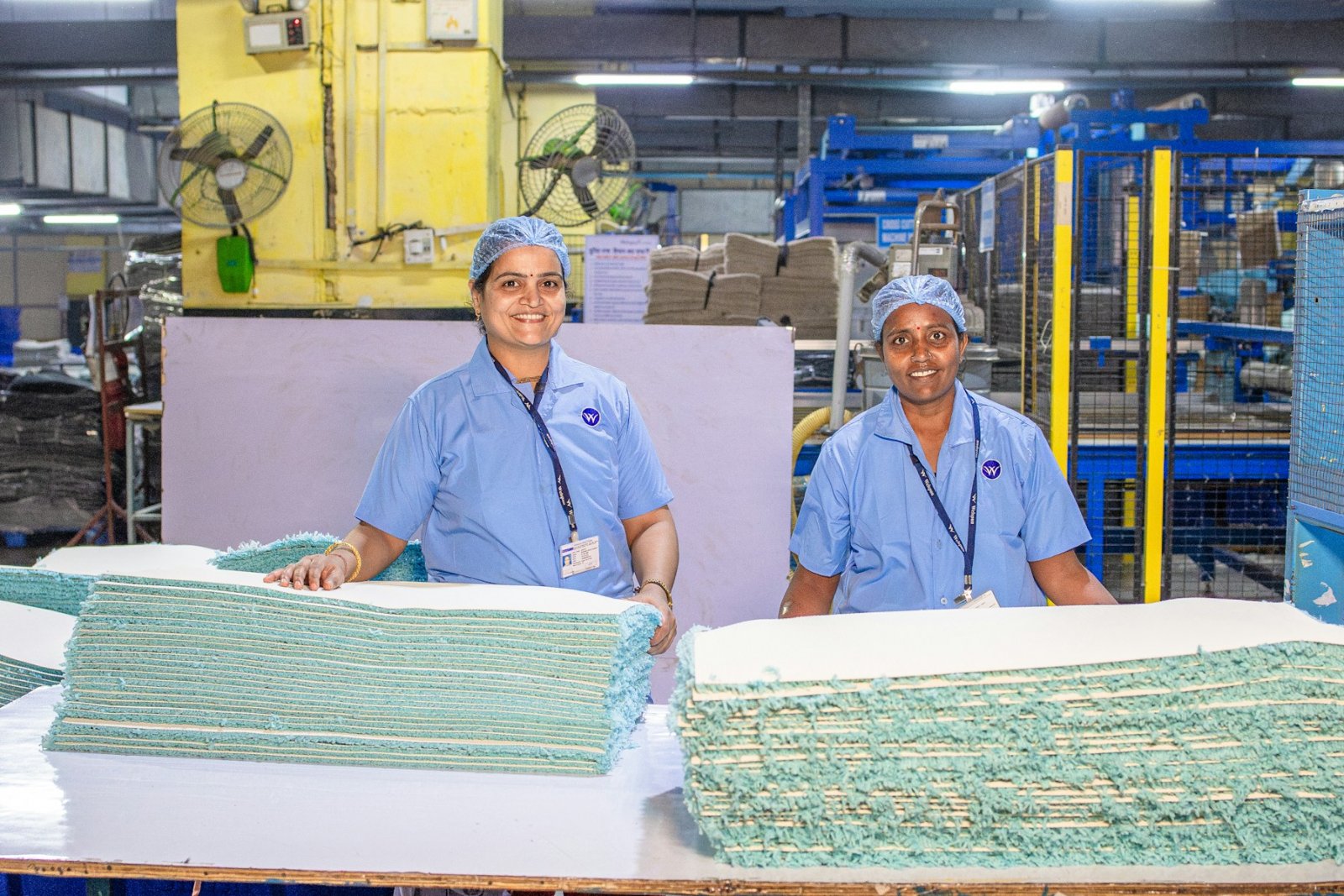Two factory workers at a packing station, smiling