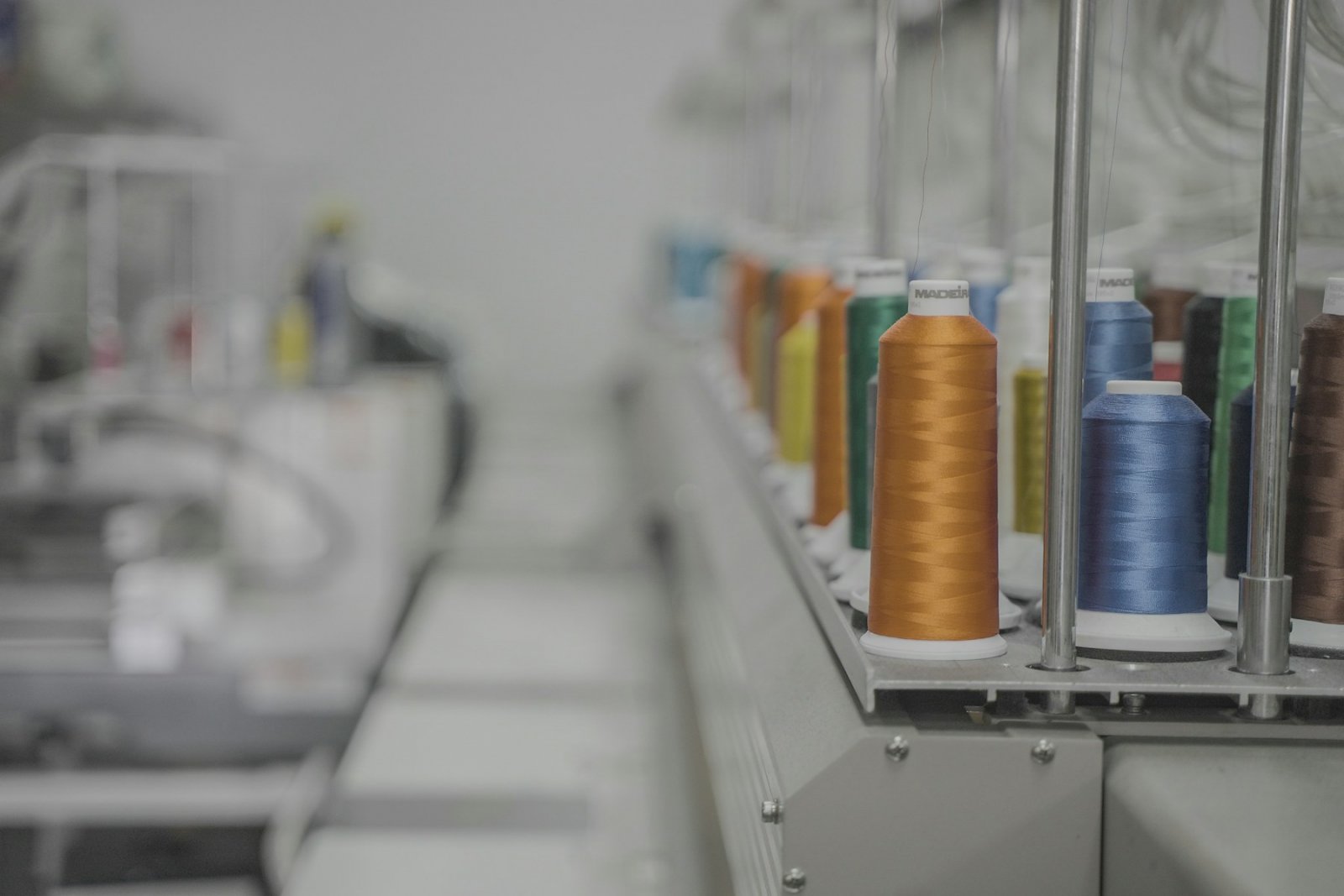 Dyed thread cones lined up on an industrial machine
